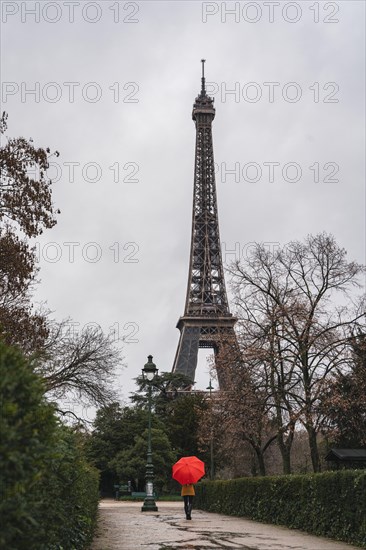 Women with red umbrella in front of the Eifel Tower