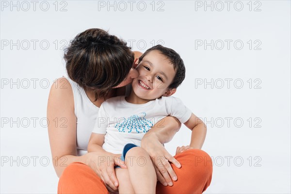 Mom hugs and kisses her little son. Family concept