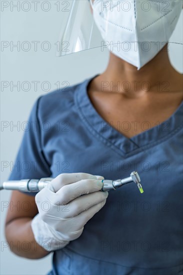 Dentist hand with gloves working with dental drill in dental office. Close-up