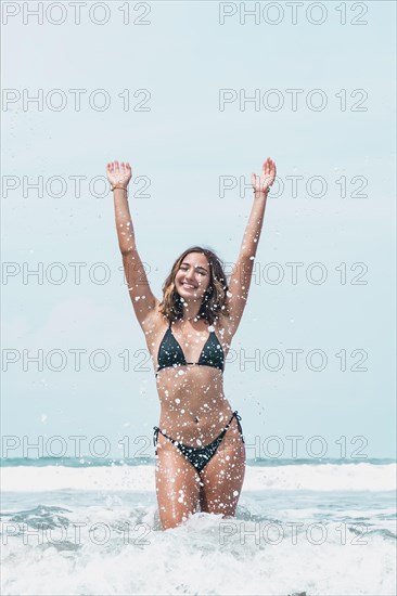 Sensual portrait of latina woman having fun on the shore of the beach