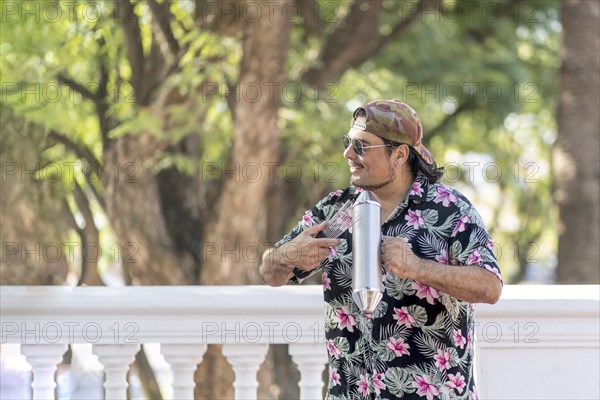 Hispanic artist playing gueiro in the street