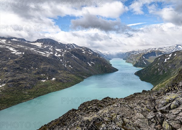 View of Lake Gjende and snowy mountains