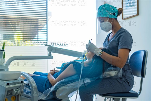 Medical professional dentist examines his patient's teeth with the use of special dental instruments