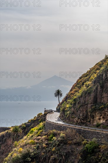 Road in the village of Agulo in the north of La Gomera with a palm tree and Tenerife in the background