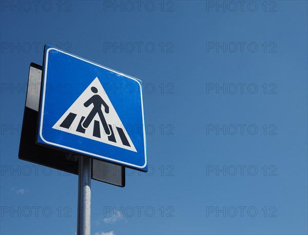 Zebra crossing sign over blue sky