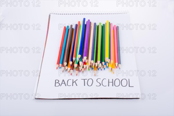 Color pencils and back to school title on a notebook