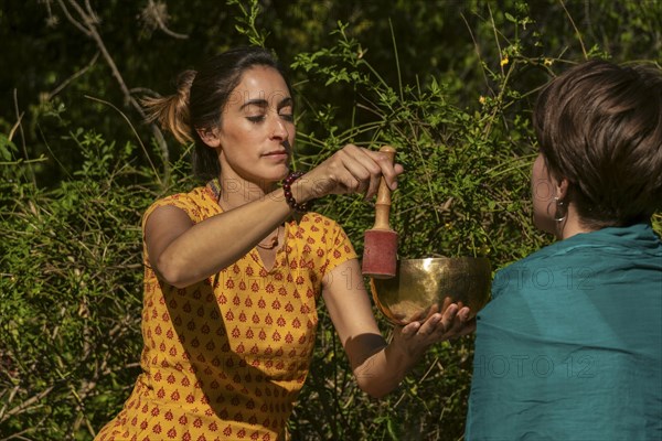 Female sound therapist with a patient in a natural setting. Concept Healing reflections. Selective focus