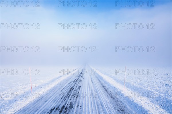 Slippery winter road in fog with snow and poor visibility in the countryside