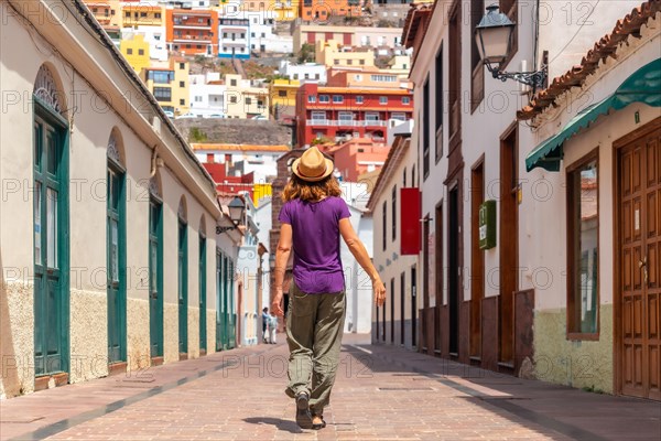 Woman on vacation walking through the city of San Sebastian de la Gomera next to the Iglesia De La Asuncion