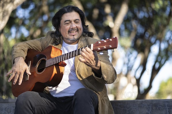 Flamenco guitarist sitting on some stairs performing