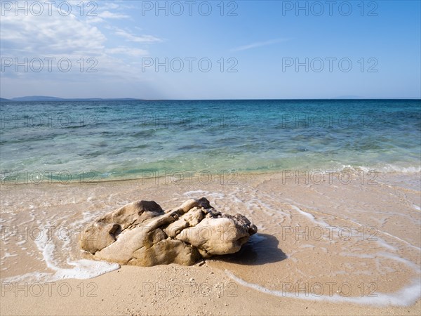 Rocks on the sandy beach near the campsite of Stara Baska