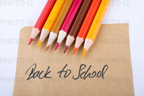 Color pencils and back to school title on a notebook