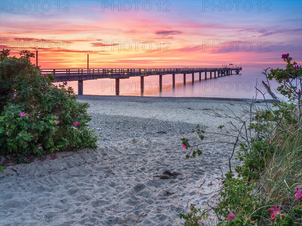 Pier on the beach of the Baltic Sea at sunset