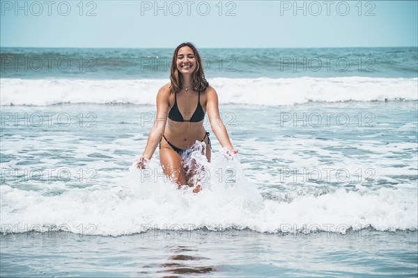 Portrait of beautiful young woman splashing in turquoise sea