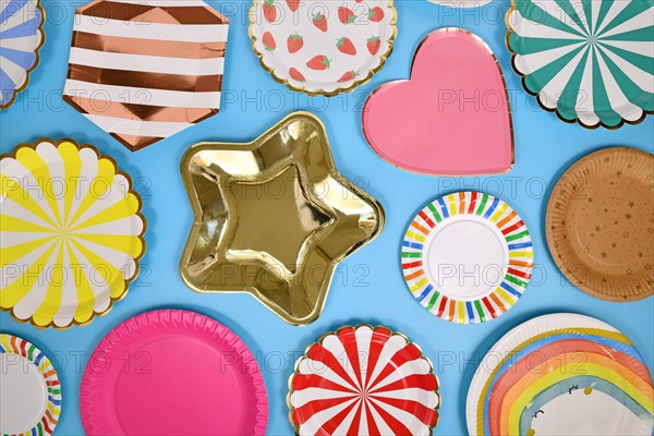 Colorful paper party plates on blue background