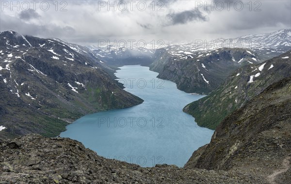 View of Lake Gjende and snowy mountains