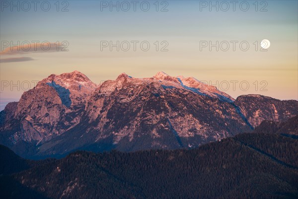 Sunrise and full moon setting over the mountains of the Reither Alpe