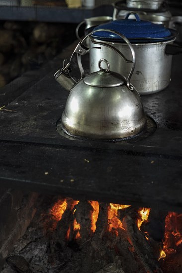 Close up of stainless steel kettle on a burning wood stove. Popular culture. Traditional food