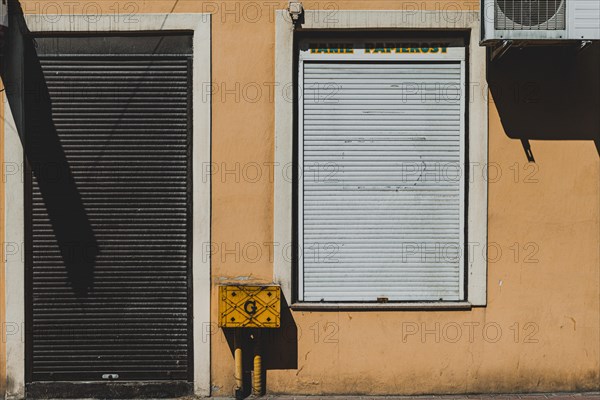 Orange wall with closed shop blinds