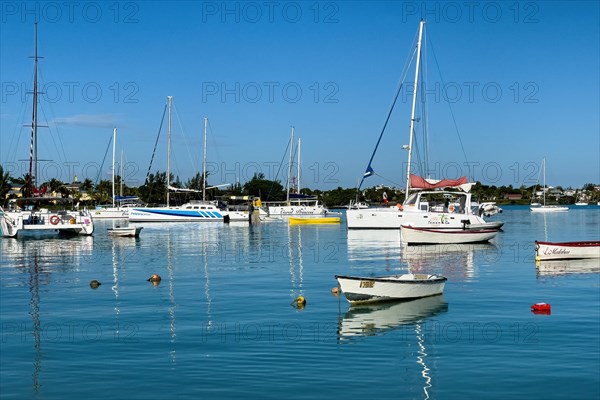 In front Small motorboat behind Sport boats Catamaran lies at anchor in smooth sea calm sea without waves in bay Grand Baie