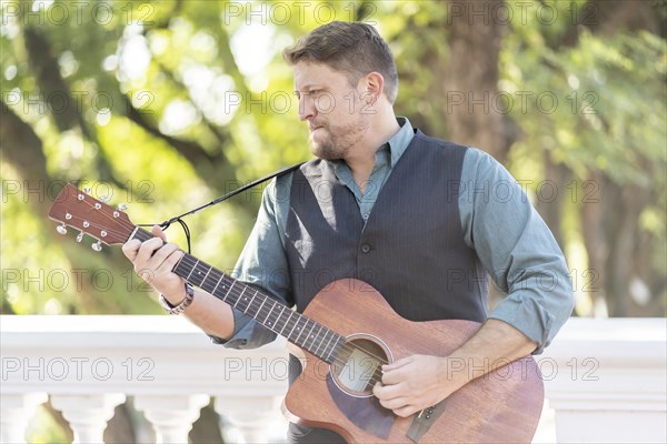Musician man playing guitar and singing in the street