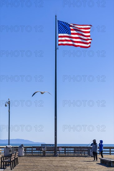 US flag waving in the wind. Vibrant colors over blue sky