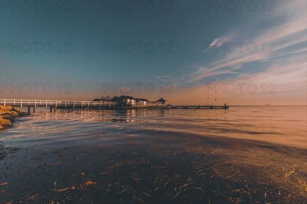 Seascape with pier at sunset