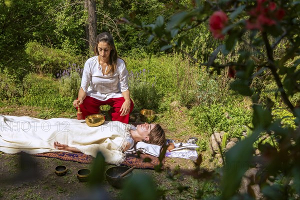 Tibetan singing bowls on belly and chest. Sound massage with singing bowls on the body. Vibrational therapy. Stress relief. Chakra alignment