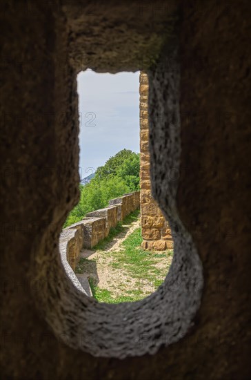 View through a keyhole in the castle walls onto parts of the outer castle complex
