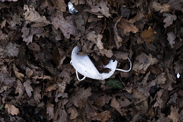 A discarded mouth-nose protection lies on the ground