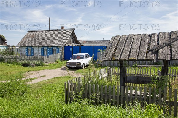 Traditional wooden house with white car