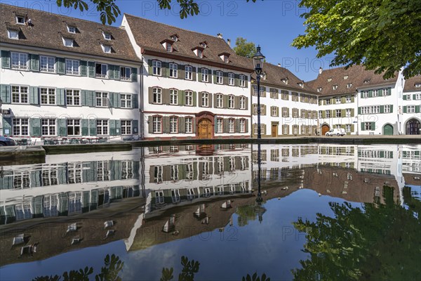 Cathedral houses reflected in the fountain on Muensterplatz in Basel