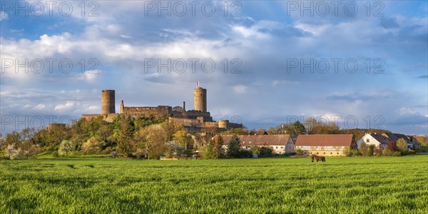 View of Muenzenberg Castle in the Wetterau under dark clouds in spring evening light