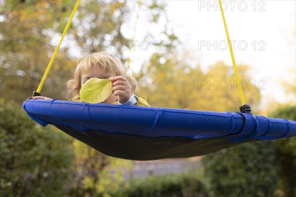 Child hiding behind a leaf