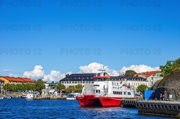 Moored ferry KOSTERSUND at the ferry terminal and picturesque view of the harbour front