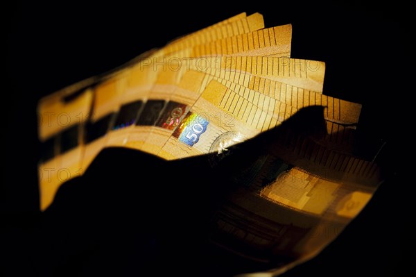 Symbolic photo on the subject of cash. 50 euro banknotes are held in one hand. Berlin