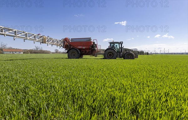 Fertiliser spreading with tractor brand Fendt 724 with 240 HP as well as fertiliser spreader Rauch Aero AGT