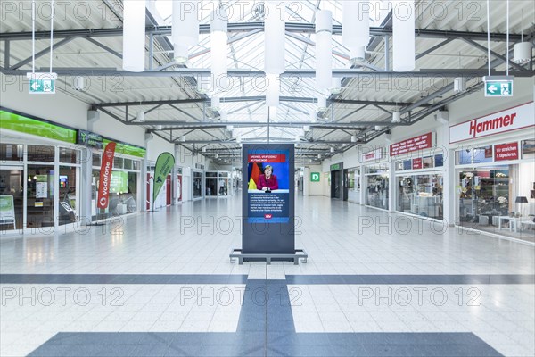 An information board shows a message with Angela Merkel