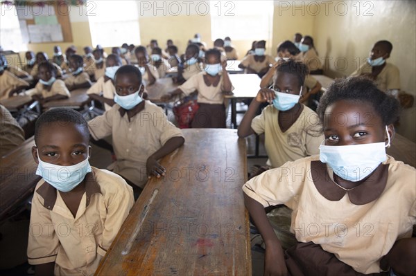 Children wearing nose-mouth protection in a school in Africa