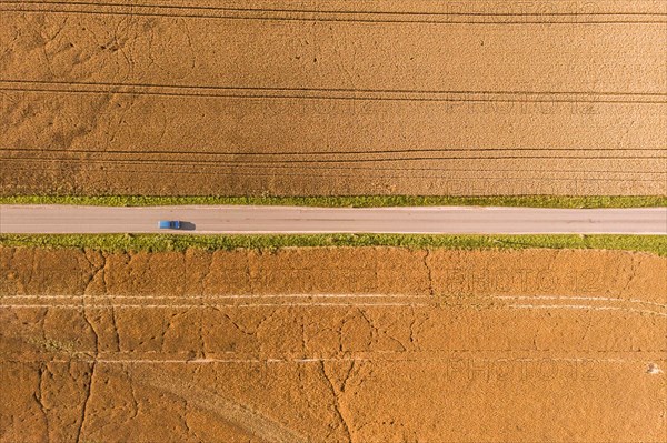 Aerial view of a country road with a blue car in Groeditz in Saxony.