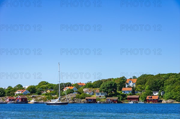 Picturesque coastal landscape with sailboat and boat shed