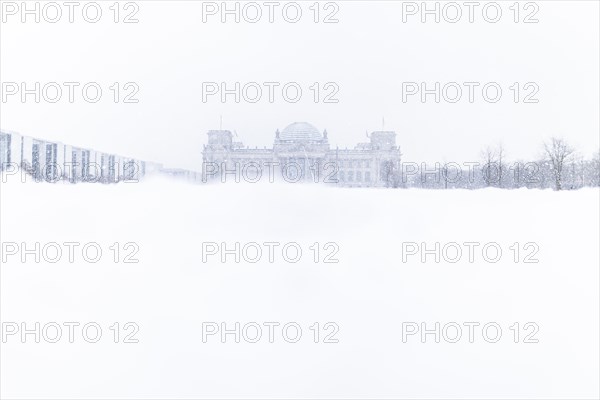 The Reichstag building is silhouetted against snowfall in the government district in Berlin