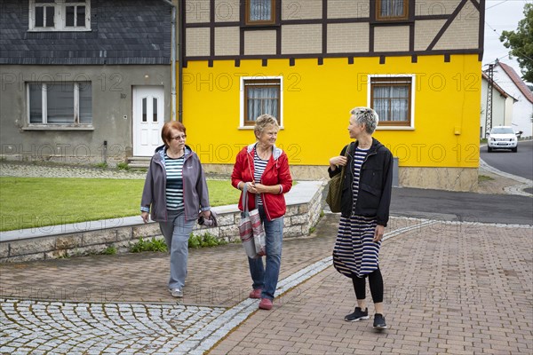 Neighbourhood. Women on the street are talking to each other.