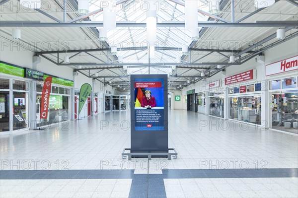 An information board shows a message with Angela Merkel