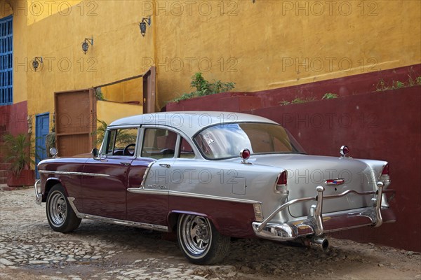 Pastel coloured house and old 1950s vintage American Chevrolet Bel Air car