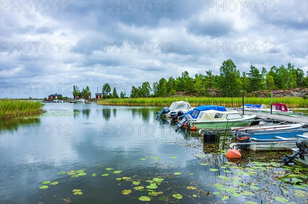 Small boats and picturesque shore landscape at the edge of Lake Vaenern in the area of Sunnana