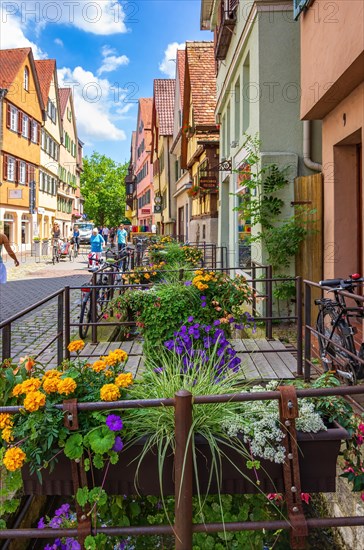 Street scene in Ammergasse with passers-by and shops as well as colourful flower decorations