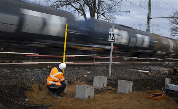 Employee of DB Netze AG measures the depth of concrete pillars on which a barrier house is to be built