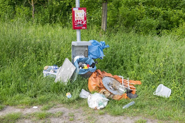 Destroyed rubbish bin with illegally deposited rubbish