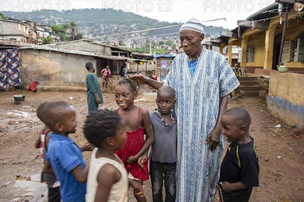 Old man with children in Bomeh Village at KissyRoad dumpsite